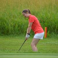 An alumna golfing on The Meadows Golf Course.